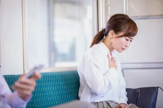 ソファーで横になり、心と体の不調について考える女性